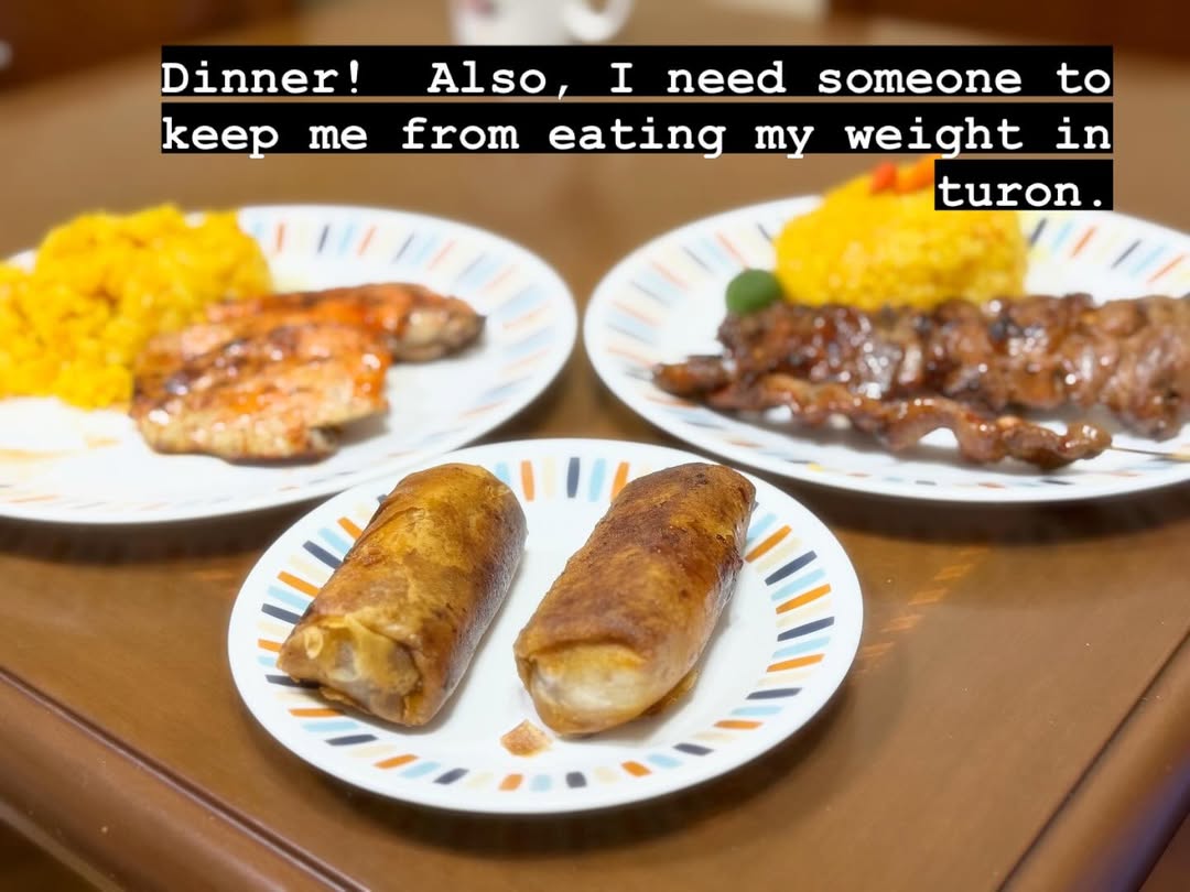 Several dinner plates on a wooden table, with browned main dishes and potatoes.