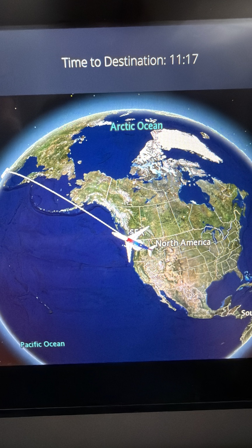 In-flight route map on a seatback screen showing the Pacific crossing with 11 hours and 17 minutes remaining.