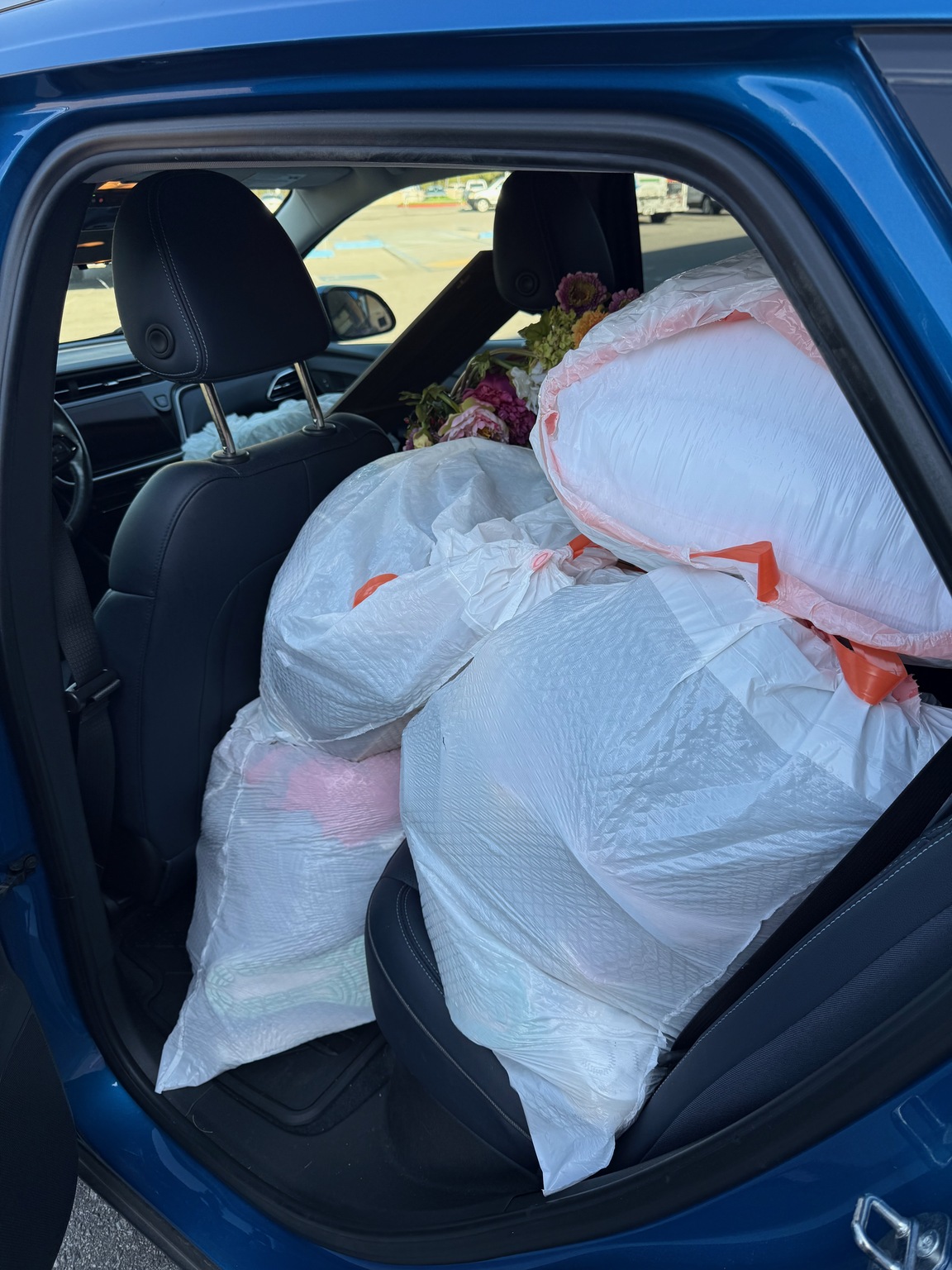 Back seat of a car packed with bags while preparing to leave
