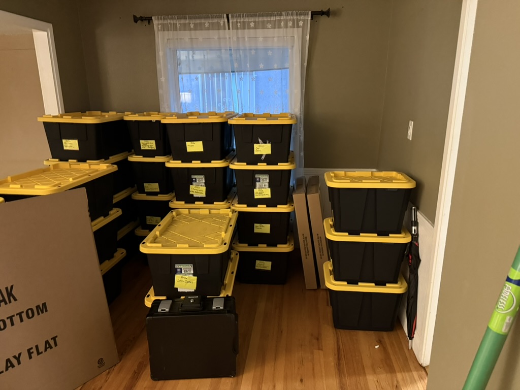 Stacked storage bins in a room during downsizing