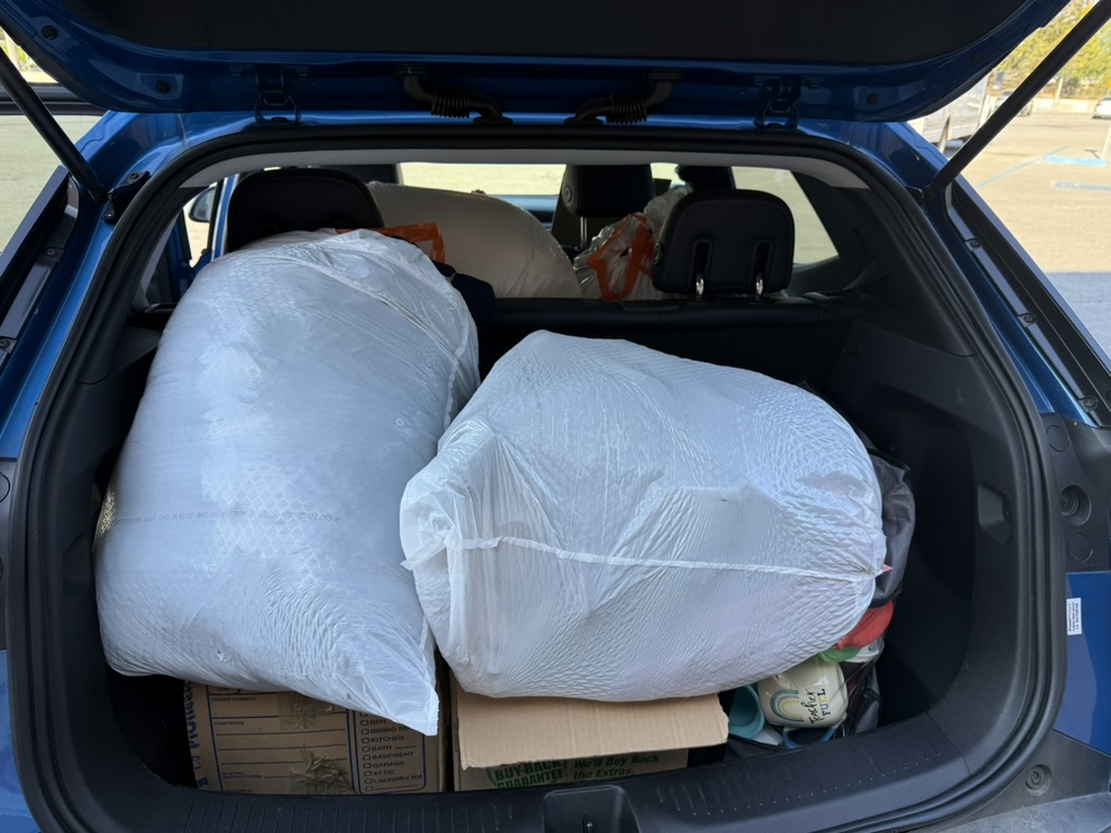 Car trunk filled with bags and boxes while preparing to leave